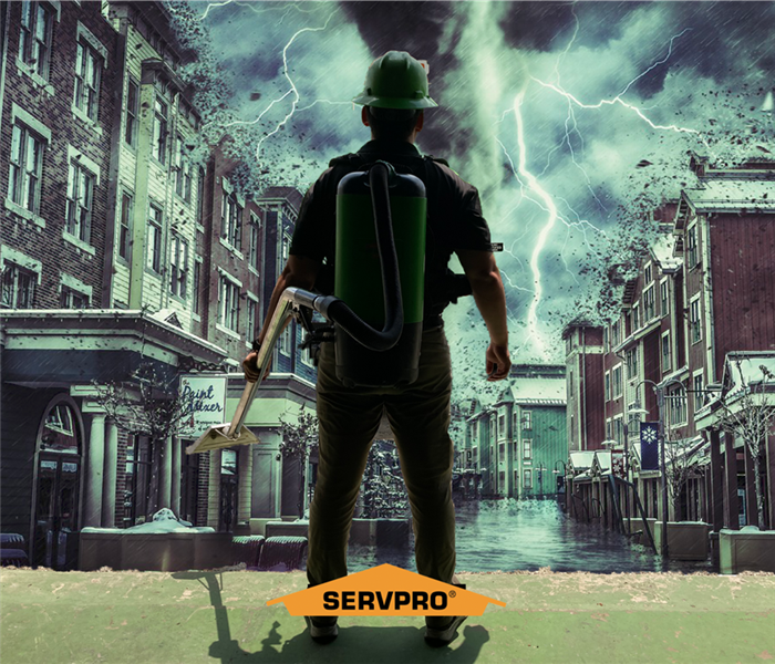SERVPRO technician standing in front of a storm with a canister vacuum on