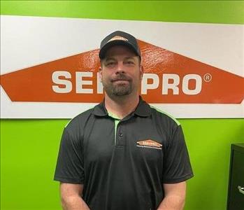 Man standing in front of a green background with SERVPRO logo. 